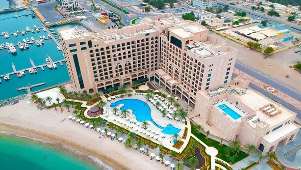 A large hotel with a central swimming pool, a beach area, and a marina. - Bask in Indian Ocean Views from a Bright & Spacious Seaside Room (Fujairah)