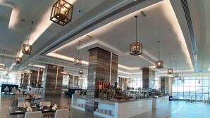 A spacious hotel lobby with modern furnishings, a central bar area, and large windows providing natural light. - Bask in Indian Ocean Views from a Bright & Spacious Seaside Room (Fujairah)