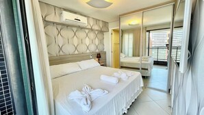 Ein Hotelzimmer mit Bett, Spiegel, Deckenleuchte und Klimaanlage.