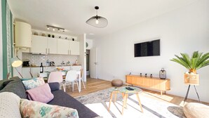 A modern living room with a sofa, coffee table, and a dining area with chairs. - Apartment Praia Rocha | Near Beach | Safira V (Portimão)