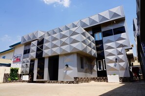 Ein modernes Gebäude mit einer geometrischen Fassade, großen Fenstern und einem flachen Dach.