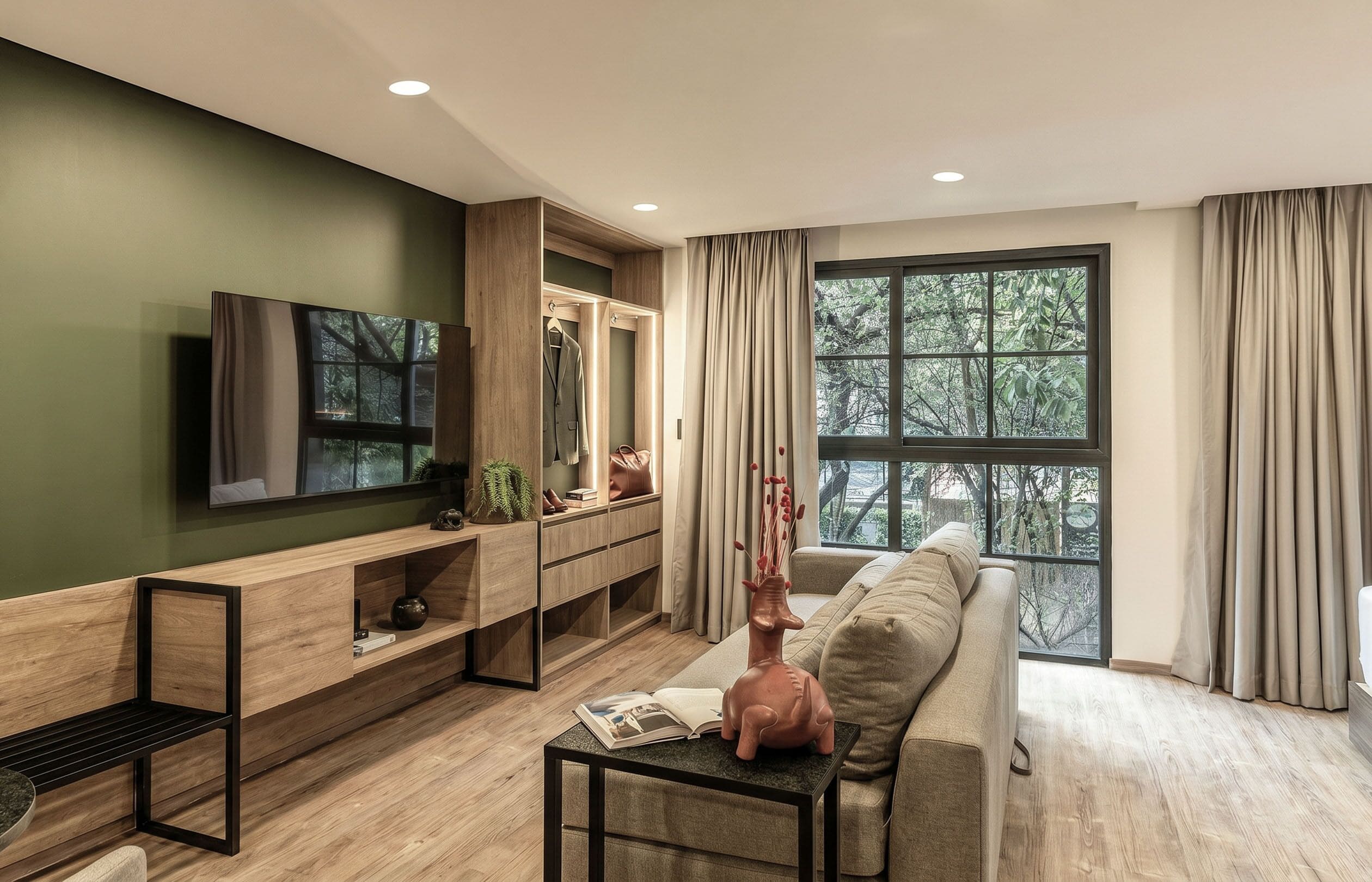 Una sala de estar moderna con televisor, sofá, consola de madera y un gran ventanal con cortinas.