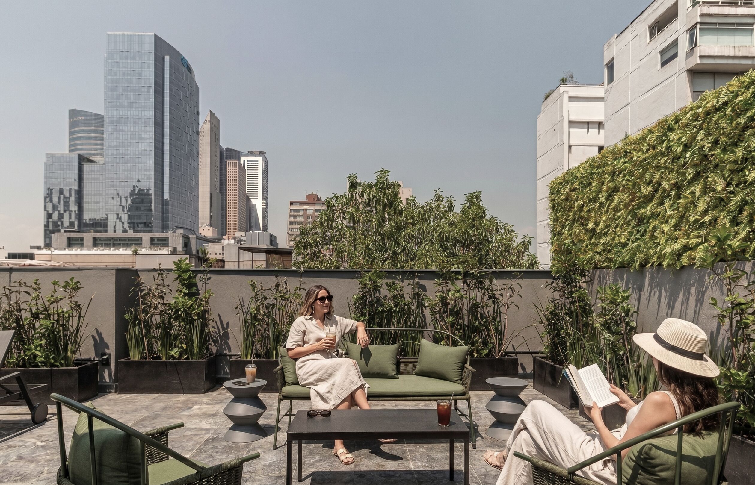 Une terrasse sur le toit, aménagée avec des sièges, une table et offrant une vue sur la ville.