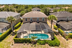 Un quartier résidentiel avec des maisons, une piscine et des toits recouverts de panneaux solaires.