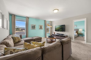 A living room with a large flat-screen TV, a sofa set, a coffee table, and a lamp. - The Ultimate Private Oasis & Game Room 6 BD/ 3.5 BA/ Solterra Resort (5140 OA) (Davenport)
