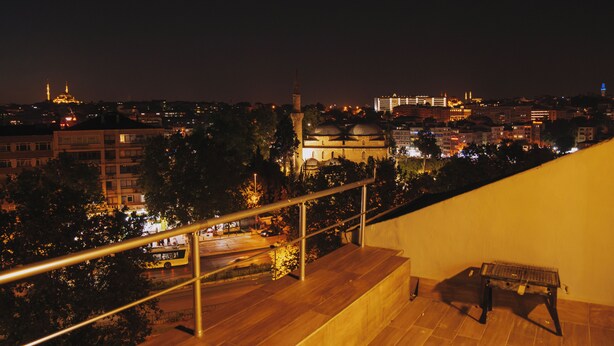 Panorama nocturno de una ciudad con vistas a una mezquita, un minarete y edificios circundantes.