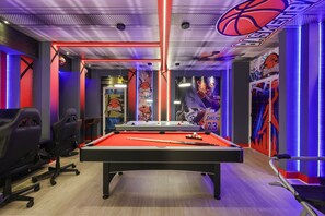 A pool table in a room with a basketball theme, including wall decorations and a ceiling with a basketball design. - Custom Theme Rooms 9 BD/5 BA/Storey Lake - 4520 TB (Kissimmee)