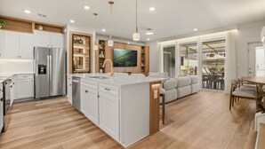 A modern kitchen with white cabinetry, stainless steel appliances, and a central island. - 5 BD/ 4.5 BA/ Windsor Cay (16218 CC) (Clermont)