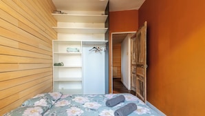Une chambre à coucher avec un lit, une armoire et un couloir.