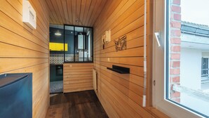 Un couloir étroit aux murs en bois et doté d’une fenêtre.