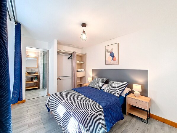 Une chambre à coucher avec un lit, une table de chevet, une lampe et une armoire.