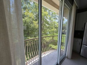 A balcony with a metal railing, a sliding glass door, and a kitchen area with cabinets and a refrigerator. - 3 BD/ 3.5  BA/ Vista Cay (5076-90 TC) (Orlando)