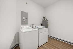 A laundry room with a washer and dryer, a utility meter, and a water heater. - Vista Cay Retreat: Stunning 3-Level Townhome/ 3 BD/ 3.5  BA (5076-90 TC) (Orlando)