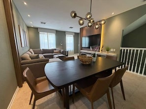 A dining area with a dark wooden table, brown chairs, and a decorative light fixture. - 3 BD/ 3.5  BA/ Vista Cay (5076-90 TC) (Orlando)