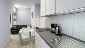 A modern kitchen with a dining area, stainless steel appliances, and a tiled backsplash. - Cozy apartment in Omisalj with WiFi (Omisalj)