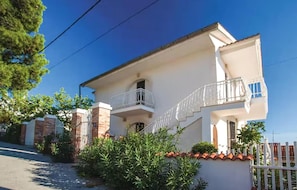 A two-story house with a balcony and a gated entrance. - 2 bedroom nice apartment in Omisalj (Omisalj)