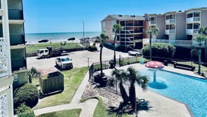 A hotel with a pool, a beach view, and a parking area. - Sandy Seawall Escape Resort (Galveston)