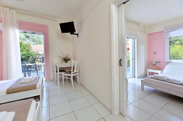 Une chambre d’hôtel comprenant un lit, un bureau, une chaise, une télévision et un balcon.