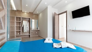 Une chambre d’hôtel équipée d’un lit, d’une armoire, d’une télévision et d’une salle de bain.