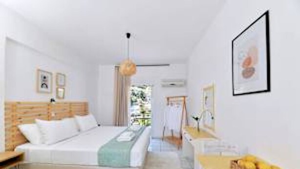 A bedroom with a bed, bedside table, and a view of the outdoors. - Ilia Edipsos Superior Gem - Quaint and Cozy (Istiaia-Aidipsos)