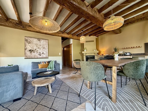 A spacious living area with a fireplace, a dining table, and a sofa.