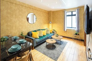 Un salon comprenant un canapé, une table basse, une table à manger et un téléviseur.