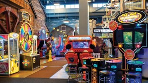 An indoor arcade with various gaming machines, including a 'Tytropon' ride and 'Pac-Man Battle Royale' game. - Great Smokies Lodge 2BR Deluxe – Water Park & Outdoor Adventure (Sevierville)