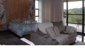 A modern bedroom with a bed, a sofa, and a balcony with a view. - Colina Haus Glampling en Armenia (Armenia)