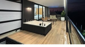 A modern balcony with a rectangular seating area, a small round table, and a potted plant. - Colina Haus Glampling en Armenia (Armenia)