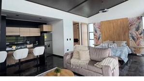 A modern living space with a sofa, a coffee table, and a dining area with chairs. - Colina Haus Glampling en Armenia (Armenia)