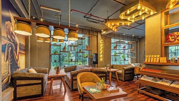 Ein modernes Interieur mit Holzböden, mehreren Sitzbereichen, Pendelleuchten und einer Kaffeebar.