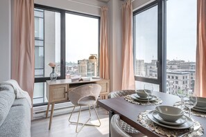 A modern living room with a dining area, large windows, and a view of the cityscape. - Skyline Penthouse | 360° Views (Montreal)