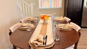 A dining table set with placemats, plates, cutlery, and glasses. - Spacious 3-bedroom New house , Feel at home (Turlock)