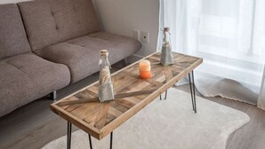 Un salon moderne avec un canapé, une table basse en bois et des objets décoratifs.