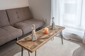 A modern living room with a sofa, a wooden coffee table, and decorative items.
