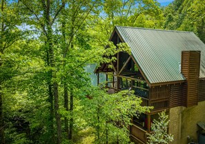 Eine Hütte mit Balkon, umgeben von dichtem Wald.