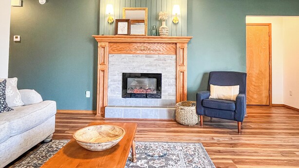 A living room with a fireplace, a sofa, a chair, and a coffee table.