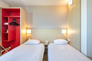 A hotel room with two beds, a red storage unit, and bedside lamps. - B&B Hotel Lyon Aeroport Saint Quentin Fallavier (Saint-Quentin-Fallavier)