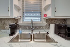 A kitchen with a double sink, a coffee maker, a bottle of dish soap, and a microwave. - Pet-Friendly 3BR • Game Room • Near Hospitals (South Euclid)