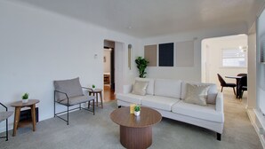 Ein modernes Wohnzimmer mit einem weißen Sofa, einem runden Couchtisch und einem minimalistischen Design.