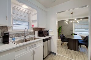 A modern kitchen with a dishwasher, a coffee maker, and a microwave. - Pet-Friendly 3BR • Game Room • Near Hospitals (South Euclid)