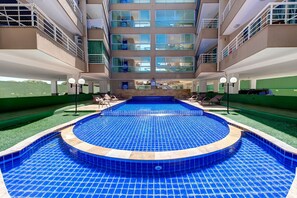 Un hôtel doté d’une piscine centrale, de nombreux balcons et offrant une vue sur les environs.