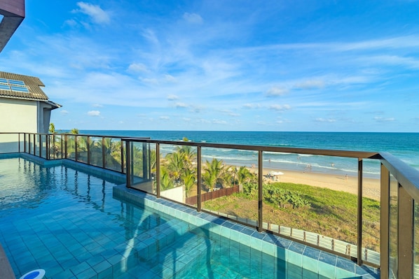 Una piscina con vista a la playa y al océano.