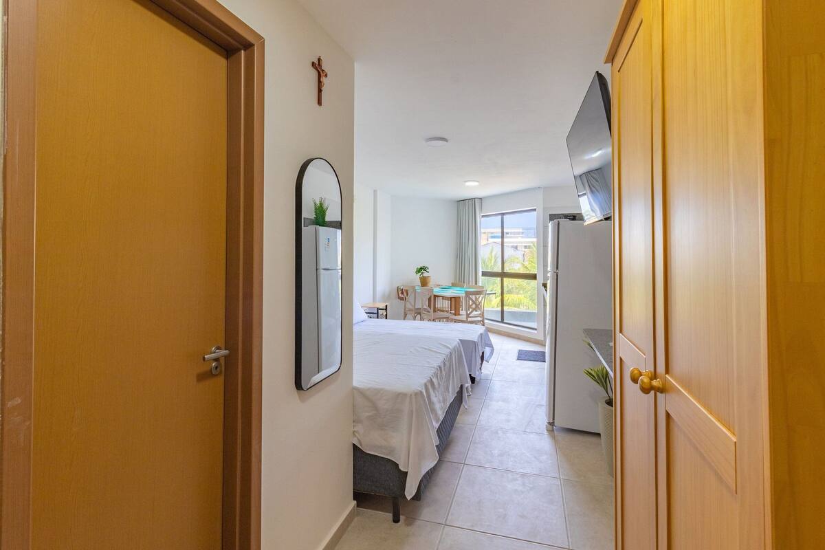 Una habitación de hotel con una cama, un escritorio, una silla, una ventana y una puerta.