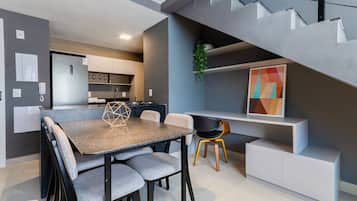 Una cocina moderna con comedor, una escalera y una planta.