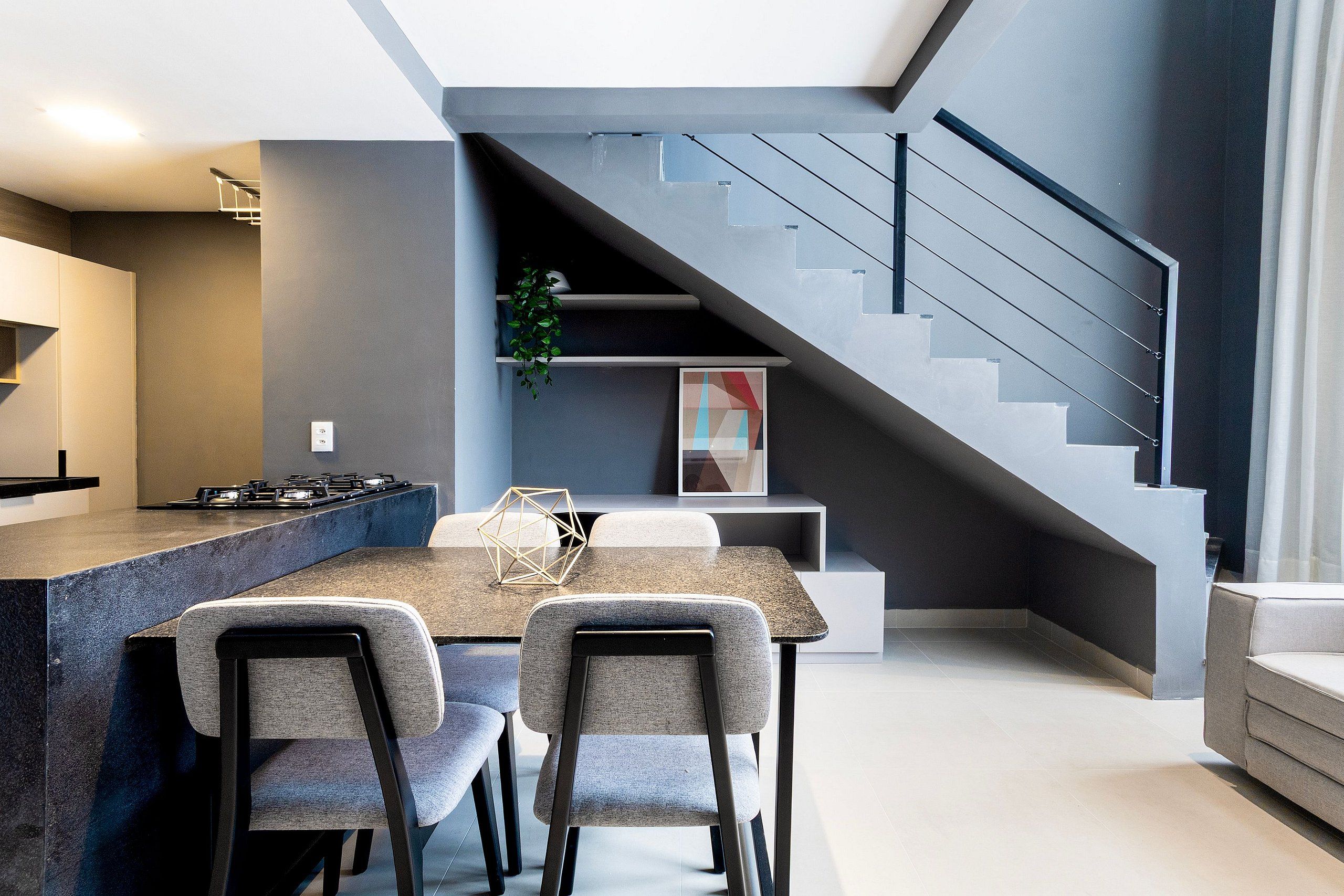 Una cocina moderna con comedor, una escalera y una sala de estar.