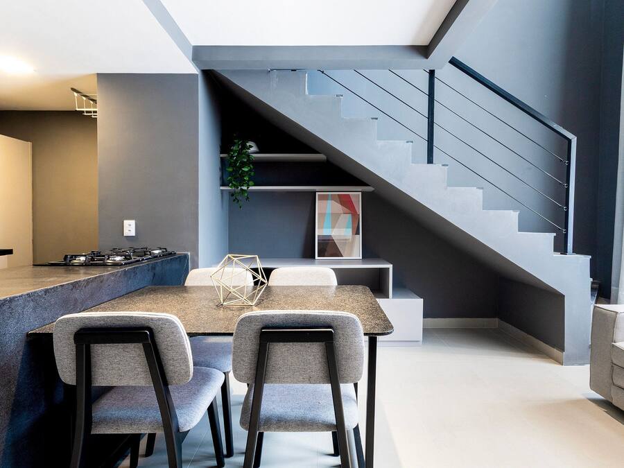 Una cocina moderna con comedor, una escalera y una sala de estar.