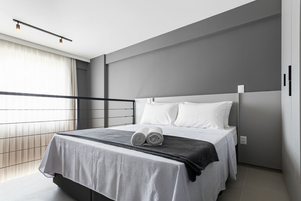 Une chambre d’hôtel moderne avec un grand lit, un balcon et une vue.