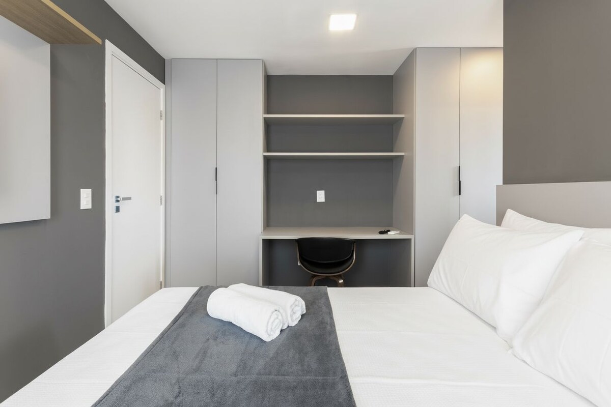Una habitación de hotel moderna con una cama, un escritorio y una silla.