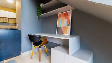 Una cocina moderna con estufa integrada, encimera blanca y una silla negra.
